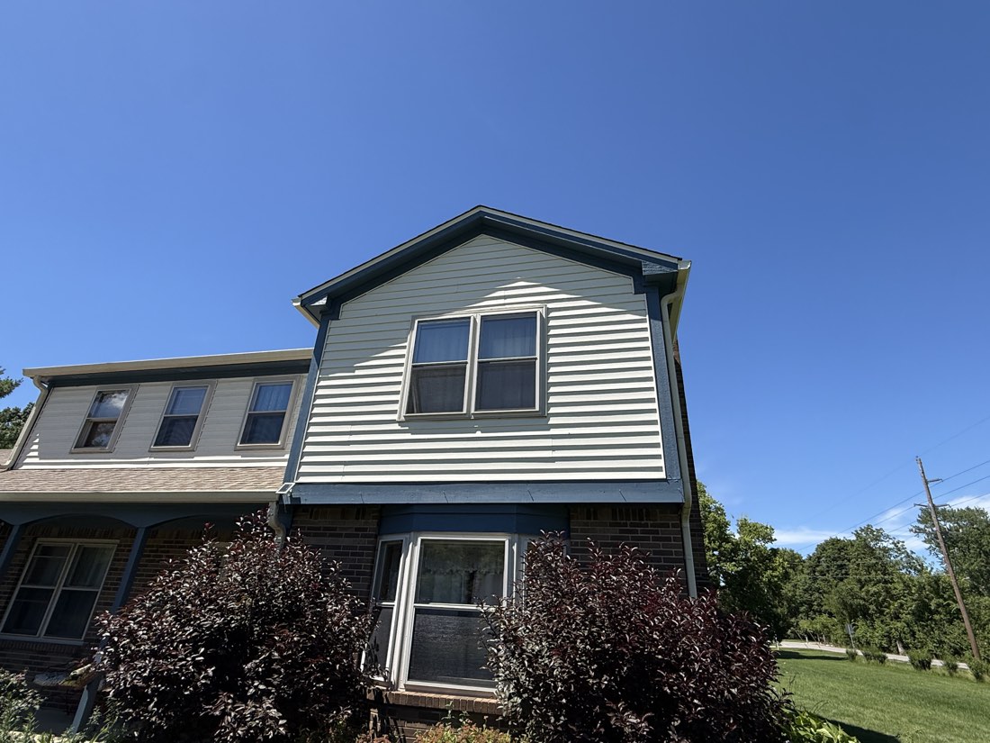 Finished gable with fresh siding and deep blue trim