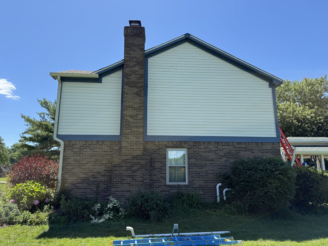 Side elevation with freshly painted siding and navy trim